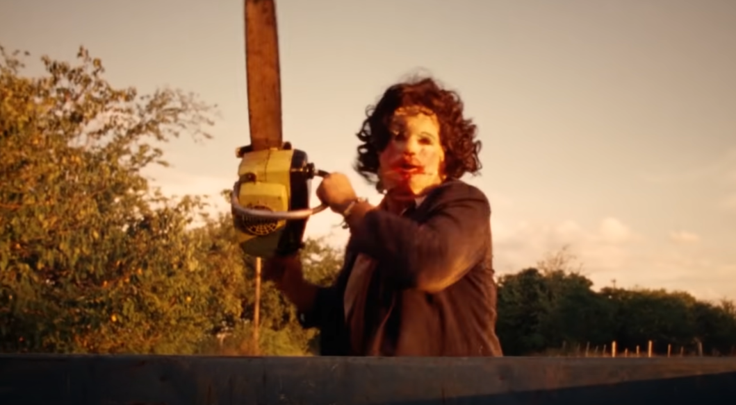 Still image of Leatherface wielding a chainsaw