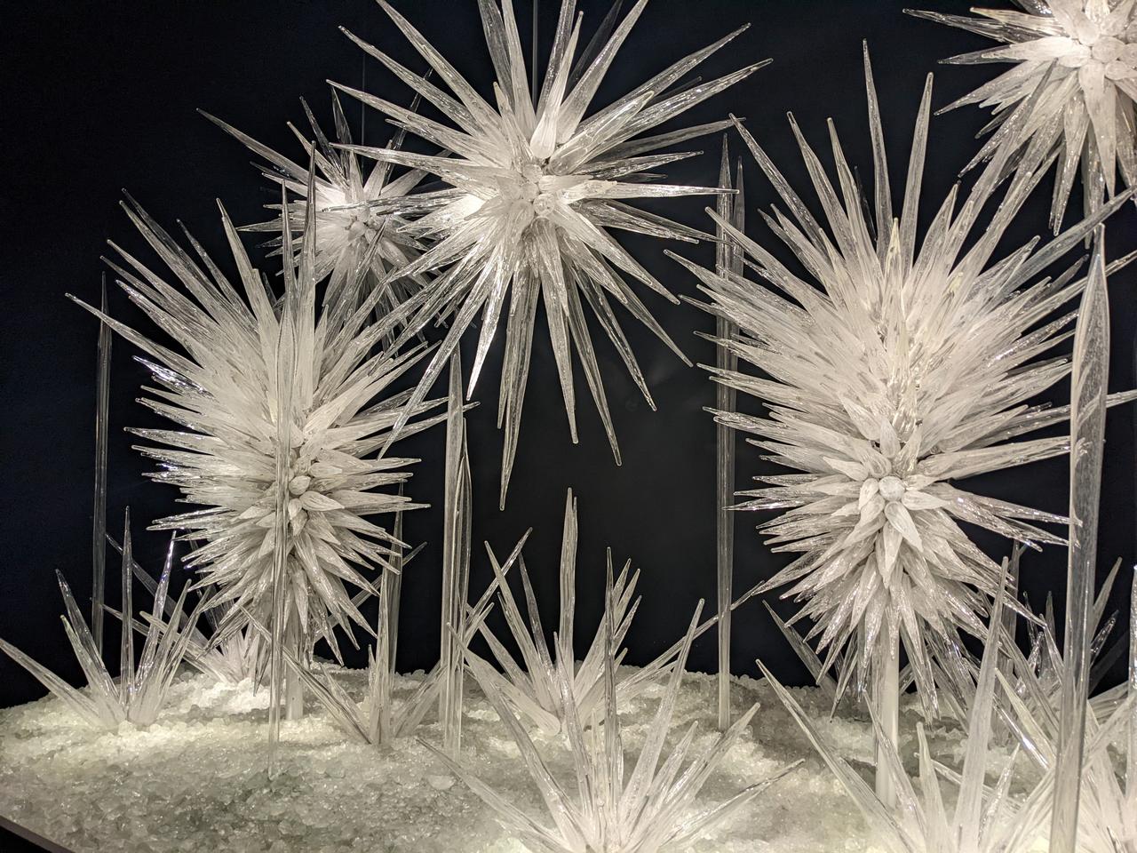 A photograph of a glass sculpture that looks like white starbursts