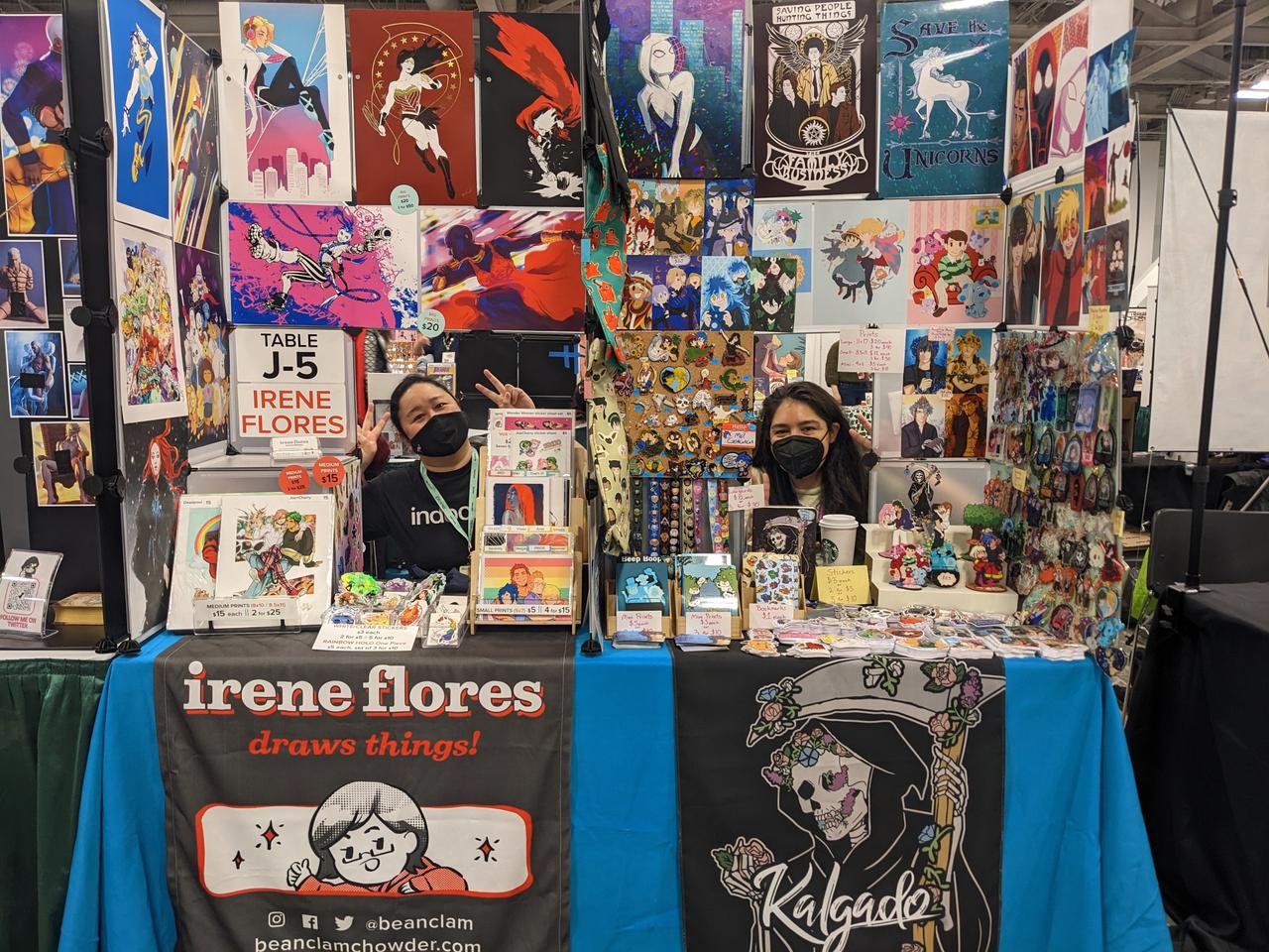 Photograph of two artists behind their table