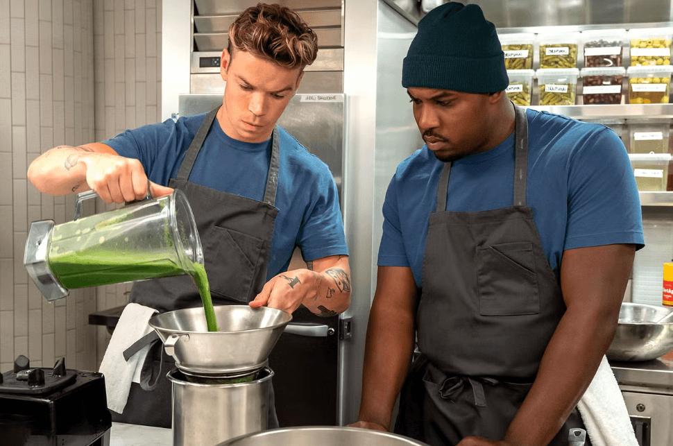 Production still of The Bear featuring Marcus watching a chef pouring from a blender into a strainer